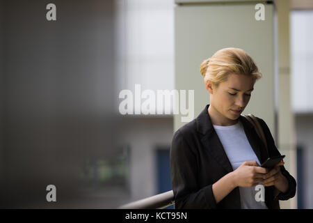 Student mit Handy in der Campus an der Hochschule Stockfoto