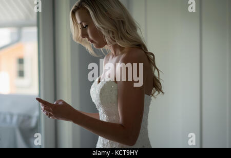 Schöne Frau mit Handy zu Hause Stockfoto