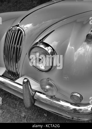 Jaguar XK-150 auf der lokalen Automobilmesse in B&W. Detail der Vorderseite des Autos und elegante Chrom-Grill und Rundleuchten. Stockfoto