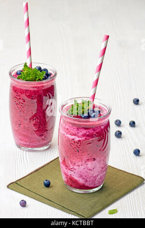 Zwei Gläser von blueberry Smoothie auf weissem Holztisch Stockfoto