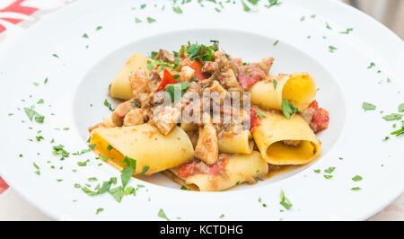 Otranto Stadt, Region Apulien, im Süden von Italien. Traditionelle Paccheri Pasta mit Schwertfisch, serviert mit Tomaten, Petersilie, Olivenöl. Tageslicht, echten Res Stockfoto