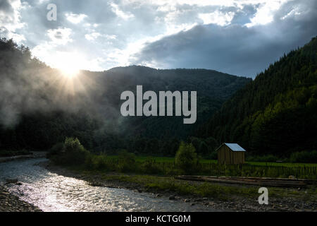 Malerischer Blick auf die vaser Fluss mit Bergen und Nebel gegen den grauen Himmel Stockfoto