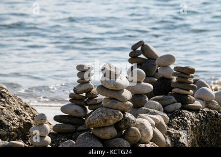 Nahaufnahme einer ausgewogenen Steine auf Felsen in der Nähe von Strand und das Ionische Meer gestapelt Stockfoto