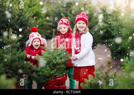 Familie auswählen Weihnachtsbaum. Kinder Auswahl frisch Norwegen Xmas Tree am Außenparkplatz. Kinder Geschenke kaufen im Winter fair. Junge und Mädchen shoppin Stockfoto