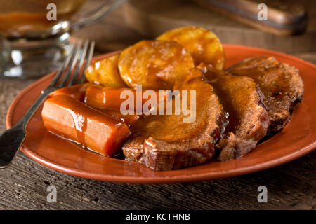 Eine köstliche hausgemachte Pot Roast Dinner mit Kartoffeln, Karotten, und Soße. Stockfoto