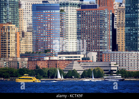 Eine geschlossene Ansicht von Bürotürmen im Finanzviertel Lower Manhattan mit Fähren im Hudson River im Vordergrund.New York City.USA Stockfoto