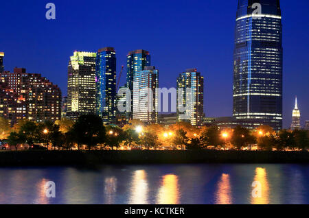 Nachtsicht auf Jersey City Skyline mit Goldman Sachs & Co Tower und Manhattan Skyline im Hintergrund.New Jersey.USA Stockfoto