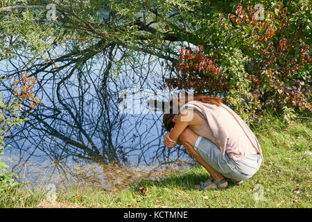 Frau in München, 24. September 2017 Frau in psychische Krise und Depression sitzen an einem See am 24. September 2017 in München, Deutschland. Modell REL Stockfoto