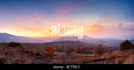 Berg herbst Panoramablick auf die Landschaft mit bunten Wald. Panorama der Sonnenuntergang in einem Karpaten Berg Tal mit wunderschönen gold Licht auf einem Hügel. Pan Stockfoto