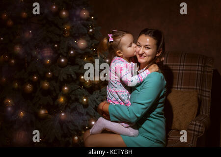 Mutter und Tochter im Wohnzimmer. Tochter küsste ihre Mutter Stockfoto