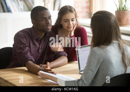 Multiethnischen paar Beschreibung Ihr Traumhaus real estate agent. afrikanische amerikanische Mann sagt Realtor Beschreibung der Residenz er will, seine Stockfoto