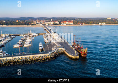 Sopot Resort in Polen. Hölzerne Seebrücke (Molo) mit Marina, Yachten, Pirate touristische Schiff, Strand, Ferienhäuser Infrastruktur. Luftaufnahme bei Sonnenaufgang Stockfoto