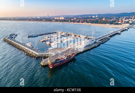 Sopot Resort in Polen. Hölzerne Seebrücke (Molo) mit Marina, Yachten, Pirate touristische Schiff, Strand, der Alte Leuchtturm, Ferienhäuser Infrastruktur. Luftaufnahme. Stockfoto