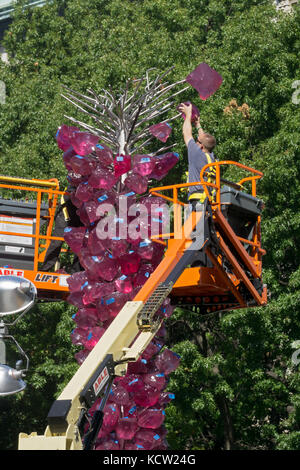 Ein Handwerker installieren von Dale Chihuly Rose Crystal Tower Glas Skulptur neben Union Square Park in Lower Manhattan, New York City. Stockfoto