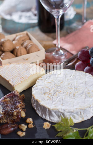 Berühmte französische Weichkäse: Camembert - köstliche Dessert mit Nüssen, Trauben und getrocknete Früchte Stockfoto