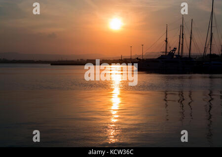 Schöne port für Luxusyachten in den Strahlen der untergehenden Sonne. Sonnenuntergang am Hafen für Yachten Yacht Club. Stockfoto