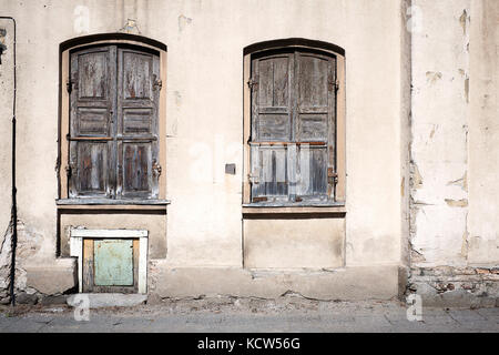 Alte grungy Wand mit geschlossenen Fenstern Stockfoto