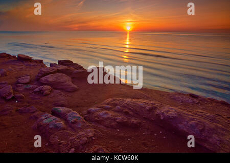 Rote Sandsteinfelsen am Golf von St. Lawrence bei Sonnenuntergang, Campbellton, Prince Edward Island, Kanada Stockfoto