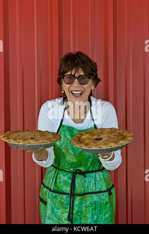 Stolz und glücklich Frau Baker anzeigen Ihr pecialty' Apple & Pfirsich Torten. Stockfoto