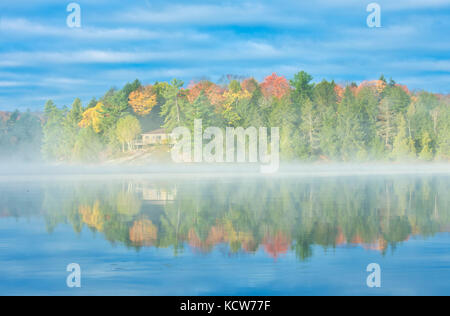 Nebel am Hufeisensee im Herbst mit Häuschen, in der Nähe von Parry Sound, Ontario, Kanada Stockfoto