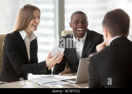 Glücklich lächelnde kaukasischen Geschäftsfrau mit digitalen Tablette zu Verhandlungen mit multinationalen Partnern, Lachen Witz auf treffen. Freundlich atmosphe Stockfoto