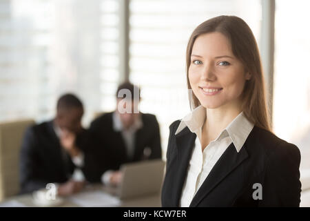 Porträt der Schönen tausendjährigen Geschäftsfrau an Kamera suchen, multinationale Unternehmer mit Laptop auf Hintergrund. Die Jugendlichen gerne weibliche Business le Stockfoto