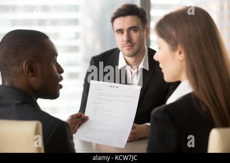 Rückansicht african american Leader analysieren und diskutieren Bewerber Lebenslauf mit weiblichen hr Specialist, kaukasische männlichen Kandidaten warten f Stockfoto