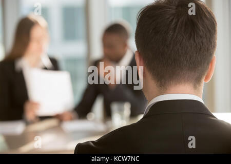 Weiße männliche Kandidaten warten auf die Arbeitgeber die Entscheidung, multinationalen hr manager Analyse fortsetzen auf Hintergrund. Mann in formale Abnutzung in Va interessiert Stockfoto