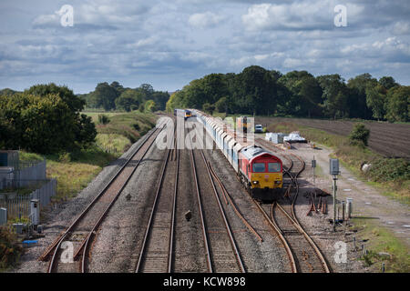 Eine erste große westliche Schnellzug überholt ein DB Cargo Güterzug am Woodborough zwischen Pewsey & Westbury, Wiltshire GROSSBRITANNIEN Stockfoto