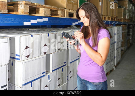 Frau schreiben in Barcode Scanner für Warehouse Inventory Management Stockfoto