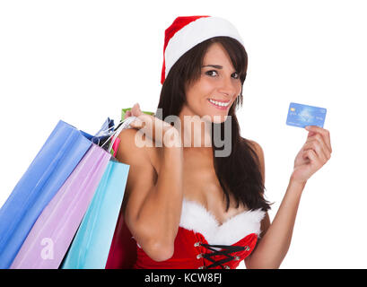 Junge Frau mit Einkaufstüten und mit Kreditkarte über weißen Hintergrund Stockfoto