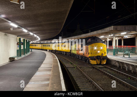 Ein Colas Railfreight Class 37 Lokomotive in Carnforth (Lancashire) mit der Network Rail Plain Line Mustererkennung Titel überwachung Zug Stockfoto