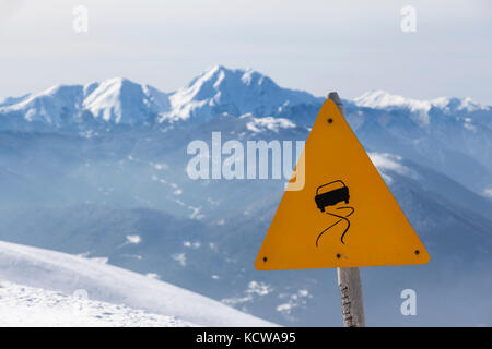 Rutschige Straßenschild, im Winter Landschaft und Berge von Schnee.