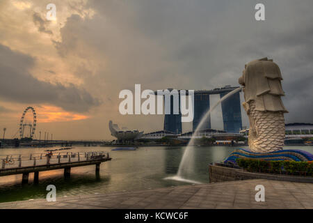 Singapur - September 10, 2017: Sonnenaufgang am Merlion Park mit Marina Bay und Singapore Flyer im Hintergrund. Der merlion ist die Stadt der meisten recogniz Stockfoto