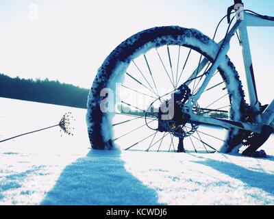 Mountainbike Urlaub im Pulverschnee. verloren weg in tiefe Schneeverwehungen. Hinterrad detail. Schneeflocken schmelzen in dunklen off road Reifen. Winterwetter in den Stockfoto