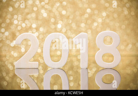 Neues Jahr 2018 weißes Holz zahlen Reflexion auf Glas Tisch vor glod Lichter bokeh. Stockfoto