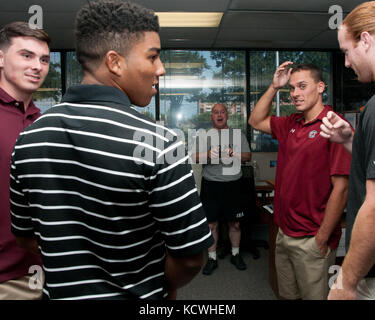 In einer freundlichen Anzeige der Wertschätzung zwischen Nachbarn, Mitglieder von der Universität von South Carolina Fußballmannschaft gestoppt durch den Bau der Adjutant Generäle in der Nähe von Williams - Brice Stadion in Columbia, South Carolina, 24, 2016 August. Die kampfhahn Fußballspieler, hayden Hurst, Brandon mcilwain, Perry Orth, Michael scarnecchia, jamari Smith und Maurer Zandi nahm sich Zeit hallo zu den Soldaten und Piloten in der South Carolina National Guard zu sagen und dankte ihnen für ihren Dienst. (U.s. army Photo vom 2nd LT. tracci dorgan) Stockfoto