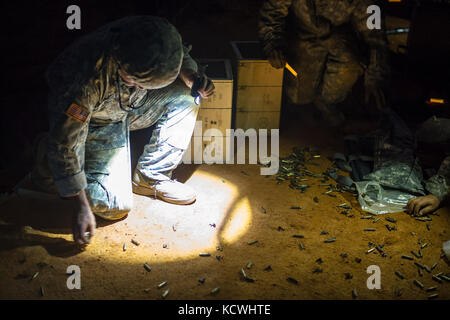 US-Soldaten, die dem 1050. Transportbataillon und dem 151. Expeditionssignal Bataillon, S.C. Armee-Nationalgarde zugewiesen wurden, sammeln Messing nach dem von der Besatzung gedienten Waffeneinarbeitung Nachttraining in Fort Jackson, S.C., 15. September 2016. 30 Soldaten aus mehreren Transport- und Signalfirmen trainieren auf demontierten Sicherheitsübungen und Mannschaftswaffen, um sich auf ihre Qualifikation im nächsten Sommer vorzubereiten und mit der Konvoi-Sicherheit auf dem neuesten Stand zu bleiben. (USA Air National Guard Foto von Tech. Sgt. Jorge Intriago) Stockfoto