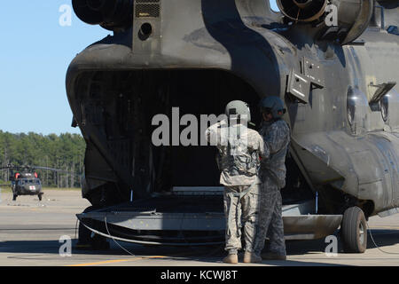 Ein Südcarolina nationalen guardâs CH-47f Chinook, ein Heavy-lift Hubschrauber, konfiguriert mit einem erweiterten Spektrum Kraftstoffsystems (erfs), auch als "fette Kuh", und seine aircrew Um das Ablösen 1 zugewiesen, Firma B, 2-238 th allgemeine Unterstützung aviation Battalion, 59th Aviation Truppe Befehl von greenville s.c., stufen ihre Basis für Operationen zur Unterstützung der Hurrikan Matthew recovery Bemühungen um mcentire joint National Guard, der eastover, s.c., Oct. 10, 2016. ca. 2000 South Carolina National Guard Soldaten und Piloten wurden in der unmittelbaren Unterstützung des Hurrikan Matthew bzw. aktiviert Stockfoto