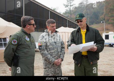 Die kolumbianische Luftwaffe col. Juan C. Rocha, 12 Air Force, luftwaffen Süden Liaison Officer, und us-armee Col. Andrew batten, South Carolina Army National Guard Deputy state Aviation Officer, mit Michael bozzo der Vorfall des South Carolina Forstverwaltung Management Team während einer Partnerschaft Programm Engagement für den Incident Command Center treffen als South Carolina Army National Guard CH-47 Chinook und UH-60 Black Hawk Besatzungen arbeiten die South Carolina Forstverwaltung ein Brand in der Nähe der Oberseite von Pinnacle Berg in Pickens County, South Carolina, Nov bis enthalten zu unterstützen. 15., 2016. Stockfoto