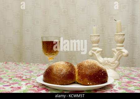 Schabbat Kerzen im Glas Leuchter mit unscharfen abgedeckt challah Hintergrund. Stockfoto