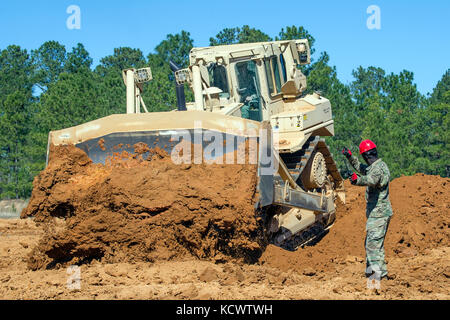 U.s. Army Staff Sgt. Edwin Williams, South Carolina Army National Guard, 218 Führung regiment Ausbilder, die Richtung zu einem raupenschlepper Bediener an mccrady Training Center in Eastover, South Carolina, Feb. 26, 2017 als Teil der horizontalen Bauingenieur Umgliederung Kurs, Soldaten in der manuvering der Traktor für eine Vielzahl von Aufgaben, einschließlich flacher Boden Grabenherstellung zu beherrschen, eine defensive formation Panzer auf dem Schlachtfeld zu verbergen. (U.s. Army National Guard Foto von Sgt. Brian Calhoun, 108 öffentliche Angelegenheiten Abteilung) Stockfoto