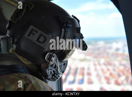 Us-Armee Sgt. David roupe, loslösung 1, Charlie Co., 2-238 allgemeine Unterstützung aviation Battalion, South Carolina Army National Guard, dient als Mannschaft Leiter auf ein UH-60 Black Hawk, fliegen neben Georgia und Louisiana Flugzeuge, während der US-Armee Sgt. David roupe, loslösung 1, Charlie Co., 2-238 allgemeine Unterstützung aviation Battalion, South Carolina Army National Guard, unterstützt mock Umsiedler auf ein UH-60 Black Hawk, fliegen neben Georgia und Louisiana Flugzeuge, während eines Hurrikans evakuierungsübung als Teil des wachsamen Schutz 17 in der Gegend von Savannah, Georgia, 29. März wachsam guard17 ist ein Stockfoto