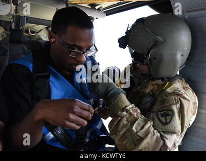 Us-Armee Sgt. dustin Keenan, Abteilung 1, Charlie Co., 2-238 allgemeine Unterstützung aviation Battalion, South Carolina Army National Guard, hilft bei der simulierten Umsiedler auf ein UH-60 Blackhawk während eines Hurrikans evakuierungsübung als Teil des wachsamen Schutz 17 in der Gegend von Savannah, Georgia, 29. März wachsam Guard 17 ist eine gemeinsame regionale Training übung für die South Carolina National Guard eine Gelegenheit, die Zusammenarbeit und die Beziehungen mit lokalen, staatlichen regionalen zivilen, militärischen und föderalen Partnern in Vorbereitung auf Notfälle und Katastrophen zu verbessern. (Us-Army National guar Stockfoto