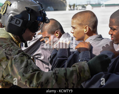 Us-Armee Sgt. David roupe, loslösung 1, Charlie Co., 2-238 allgemeine Unterstützung aviation Battalion, South Carolina Army National Guard, unterstützt die simulierte Umsiedler auf ein UH-60 Black Hawk, fliegen neben Georgia und Louisiana Flugzeuge, während eines Hurrikans evakuierungsübung als Teil des wachsamen Schutz 17 in der Gegend von Savannah, Georgia, 29. März wachsam Guard 17 ist eine gemeinsame regionale Training übung für die South Carolina National Guard eine Gelegenheit, die Zusammenarbeit und die Beziehungen mit lokalen, staatlichen regionalen zivilen, militärischen und föderalen Partnern in Vorbereitung für emergenc zu verbessern. Stockfoto