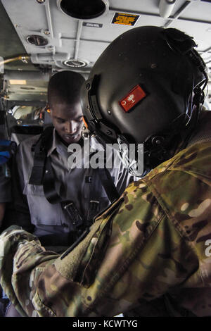 Us-Armee Sgt. David roupe, loslösung 1, Charlie Co., 2-238 allgemeine Unterstützung aviation Battalion, South Carolina Army National Guard, unterstützt die simulierte Umsiedler auf ein UH-60 Black Hawk, fliegen neben Georgia und Louisiana Flugzeuge, während eines Hurrikans evakuierungsübung als Teil des wachsamen Schutz 17 in der Gegend von Savannah, Georgia, 29. März wachsam Guard 17 ist eine gemeinsame regionale Training übung für die South Carolina National Guard eine Gelegenheit, die Zusammenarbeit und die Beziehungen mit lokalen, staatlichen regionalen zivilen, militärischen und föderalen Partnern in Vorbereitung für emergenci zu verbessern. Stockfoto