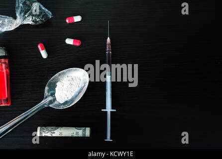 Harte Drogen auf dunklen Tisch. Ein dunkles Thema, Drogenkonsum. Ansicht von oben mit der Kopie Raum Stockfoto