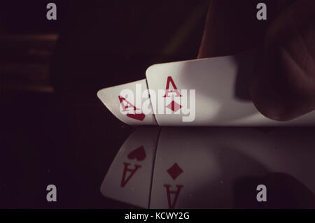 Die menschliche Hand, die zwei Asse auf schwarzem Hintergrund Stockfoto