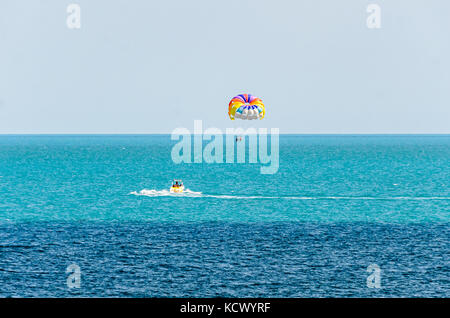 Farbige parasail Flügel mit einem Boot im Meer Wasser gezogen, auch bekannt als Parasailing oder parakiting Parasailing. Stockfoto