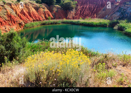 Der See in roten Böden ist eine alte Bauxit Steinbruch Höhle in Apulien, Salento, Otranto, Italien. Das Graben wurde mit natürlichem Wasser gefüllt. Stockfoto